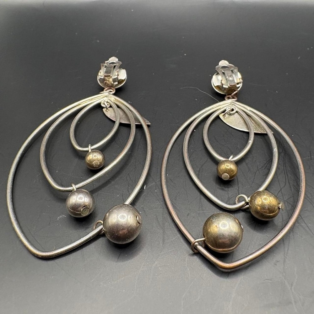 Silver and gold tone statement earrings with three concentric oval hoops